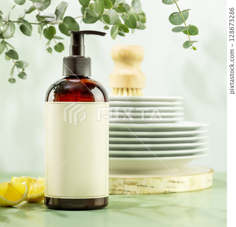 Mockup of natural dish detergent. Eco friendly cleaning dishes. Sustainable still life with bottle with dish detergent with clean plates on blue background with lemon slices and sprig of eucalyptus 128673286