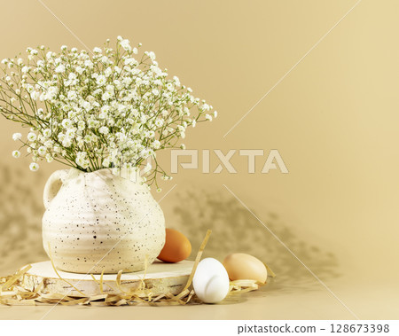 Easter holiday still life with white flowers in vase and eggs on wooden podium on beige background with shadows and copy space. Spring time. Congratulatory easter background Easter holiday still life with white flowers in vase and eggs on wooden podium on beige background with shadows and copy space. Spring time. Congratulatory easter background 128673398