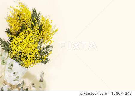 Bouquet with mimosa branches on a light background. Eco friendly holiday card with mimosa flowers. Floristic spring background suitable for mothers day or womans day. Flat lay, copy space Bouquet with mimosa branches on a light background. Eco friendly holiday card with mimosa flowers. Floristic spring background suitable for mothers day or womans day. Flat lay, copy space 128674242