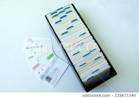 A box full of business cards and a row of business cards A box full of business cards and a row of business cards 128675340