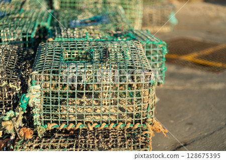 Crab Traps Stacked on a Dock During Late Afternoon Crab Traps Stacked on a Dock During Late Afternoon 128675395