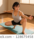 健康的女人在流汗的同時做瑜珈伸展。 128675458