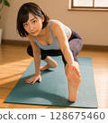 一名女子在室內做瑜珈伸展。 128675460