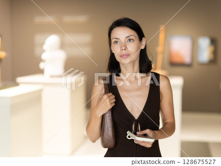 Young woman at a sculpture exhibition Young woman at a sculpture exhibition 128675527