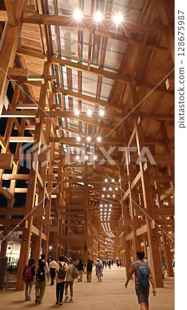 大阪關西世博會:人們在燈光璀璨的環形屋頂下漫步 大阪關西世博會:人們在燈光璀璨的環形屋頂下漫步 128675987