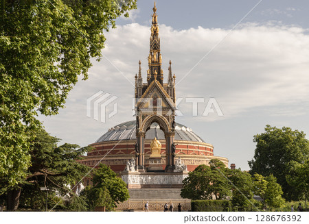 the Albert Memorial in Kensington Gardens with the Royal Albert Hall visible directly behind it. 128676392