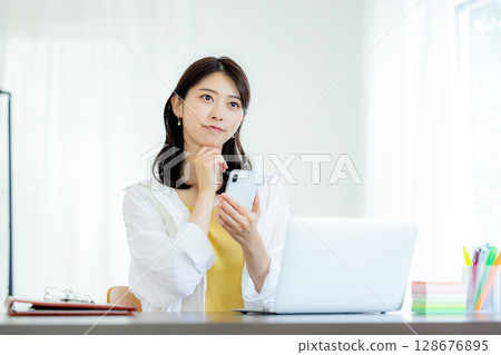 A woman watching a smartphone 128676895