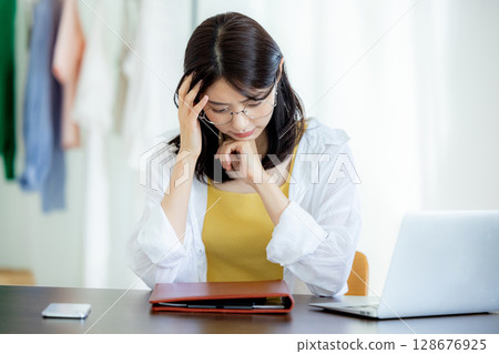一位年輕女士在使用筆記型電腦時遇到困難 128676925