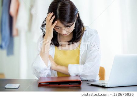 一位年輕女士在使用筆記型電腦時遇到困難 128676926
