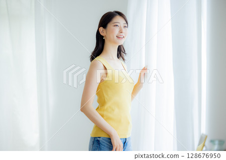 Woman opening curtain 128676950