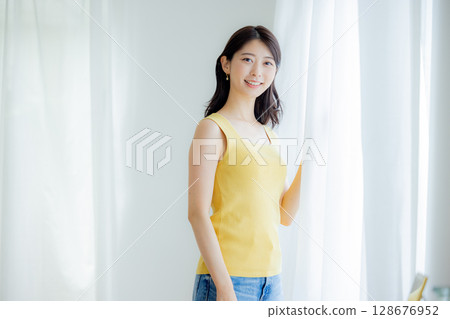 Woman opening curtain 128676952