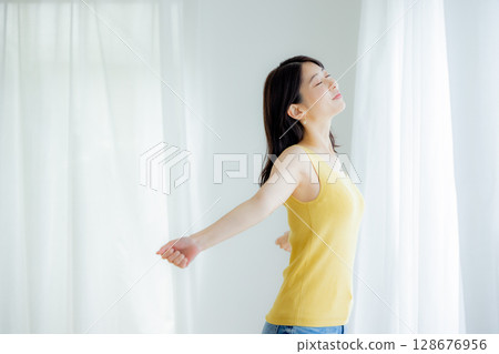 Woman opening curtain 128676956