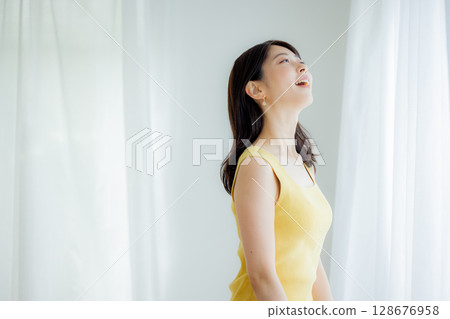 Woman opening curtain Woman opening curtain 128676958
