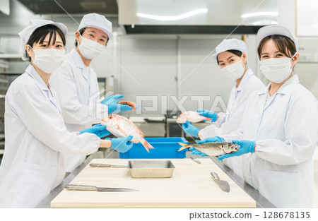 Male and female staff in chef coats preparing fish (chef, chef, fresh market, food processing) Male and female staff in chef coats preparing fish (chef, chef, fresh market, food processing) 128678135