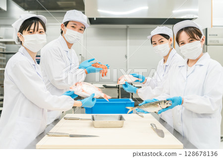 身穿廚師服的男女工作人員煮魚(廚師、廚師、菜市場、食物加工) 身穿廚師服的男女工作人員煮魚(廚師、廚師、菜市場、食物加工) 128678136