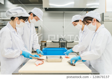身穿廚師服的男女工作人員煮魚(廚師、廚師、菜市場、食物加工) 身穿廚師服的男女工作人員煮魚(廚師、廚師、菜市場、食物加工) 128678137