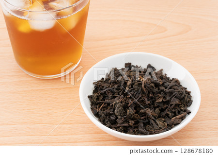 Oolong tea in a glass and tea leaves 128678180