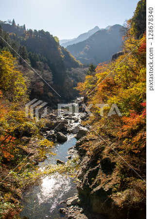 Autumn scenery of the Arakawa River flowing through Chichibu City and the valley colored with autumn leaves 128678340