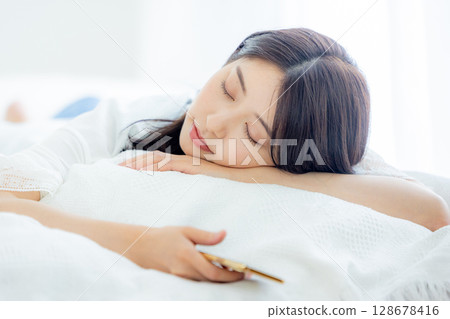 A woman sleeping in bed A woman sleeping in bed 128678416