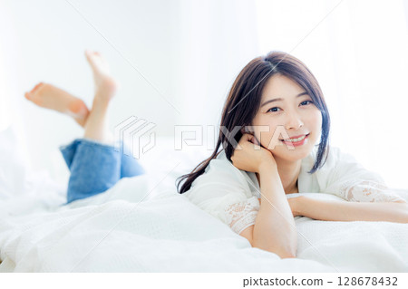 Young woman waking up in the bedroom 128678432