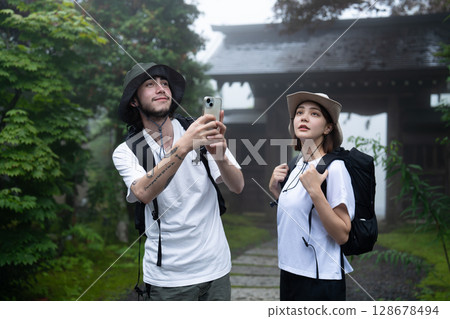 一對入境情侶在旅館的花園拍照 128678494