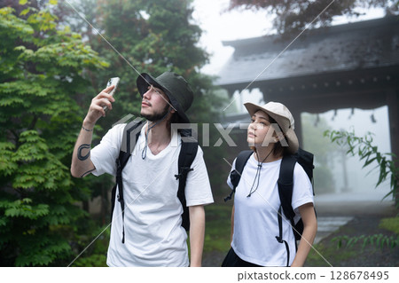 一對入境情侶在旅館的花園拍照 128678495