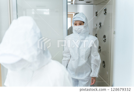 People who work in factories with air showers and clean rooms People who work in factories with air showers and clean rooms 128679332