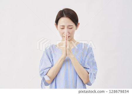 Woman, middle-aged, praying, hands together, white background 128679834