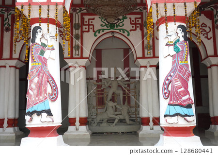 Traditional Bengali Courtyard with Unfinished Durga Idol and Decorative Painted Pillars 128680441