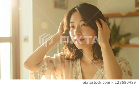 Japanese woman combing her hair in front of the mirror in the morning 128680459