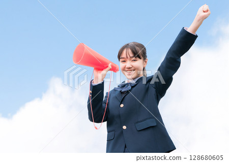 High school and junior high school girls in blazers cheering with megaphones 128680605