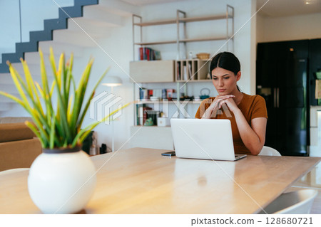 Woman sitting in living room using laptop looking at cam talk by video call with business friend relatives, head shot. Job interview answering questions 128680721