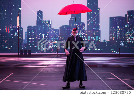 Mysterious Clown Performer with Red Umbrella in Urban Nightscape. Mysterious Clown Performer with Red Umbrella in Urban Nightscape. 128680750