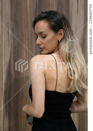 Elegant Blonde in a Black Dress Exuding Confidence and Timeless Beauty. Elegant Blonde in a Black Dress Exuding Confidence and Timeless Beauty. 128680758