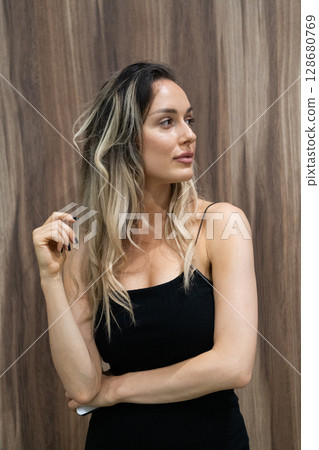 Elegant Blonde in a Black Dress Exuding Confidence and Timeless Beauty. 128680769