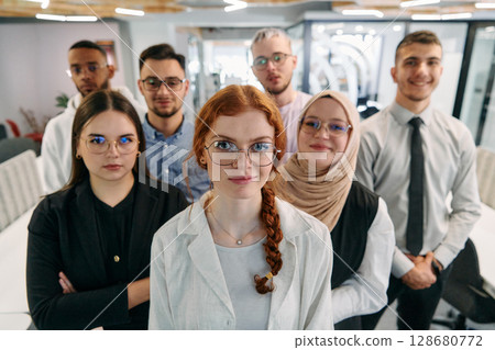 A group of business professionals standing together, taking a well-deserved break from their busy workday, showcasing camaraderie, teamwork, and a moment of relaxation in their dynamic workplace A group of business professionals standing together, taking a well-deserved break from their busy workday, showcasing camaraderie, teamwork, and a moment of relaxation in their dynamic workplace 128680772