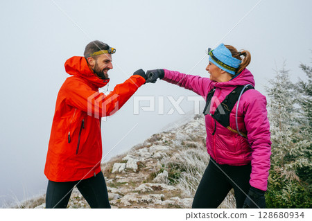 Trail running couple man and woman running on a mountain path Trail running couple man and woman running on a mountain path 128680934