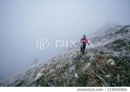 Trail Runner in Misty Mountain Landscape 128680960