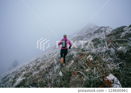 Trail Runner in Misty Mountain Landscape 128680961