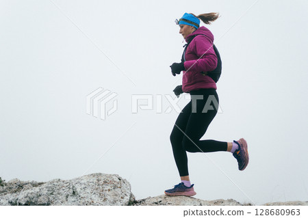 Trail Runner in Misty Mountain Landscape 128680963