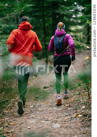 Happy Couple Running on a Forest Trail Happy Couple Running on a Forest Trail 128681036