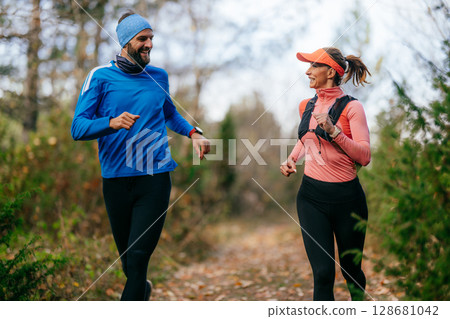 Happy Couple Running on a Forest Trail Happy Couple Running on a Forest Trail 128681042