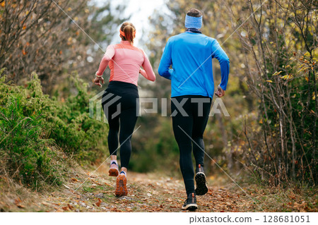 Happy Couple Running on a Forest Trail Happy Couple Running on a Forest Trail 128681051