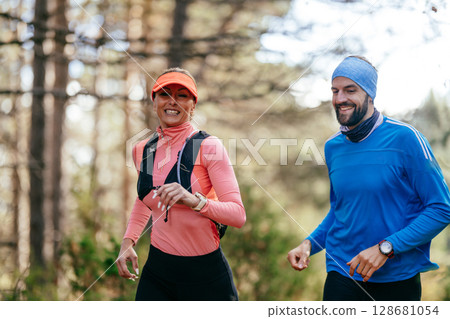 Happy Couple Running on a Forest Trail Happy Couple Running on a Forest Trail 128681054