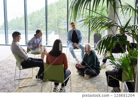 Corporate business team meeting with a manager or coach. Group of happy diverse, multiracial people sitting in a circle Corporate business team meeting with a manager or coach. Group of happy diverse, multiracial people sitting in a circle 128681204