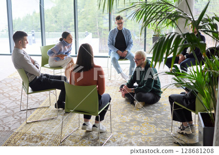 Corporate business team meeting with a manager or coach. Group of happy diverse, multiracial people sitting in a circle Corporate business team meeting with a manager or coach. Group of happy diverse, multiracial people sitting in a circle 128681208