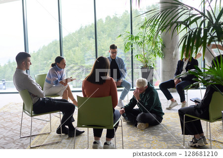 Corporate business team meeting with a manager or coach. Group of happy diverse, multiracial people sitting in a circle  128681210