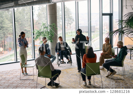 Corporate business team meeting with a manager or coach. Group of happy diverse, multiracial people sitting in a circle  128681216