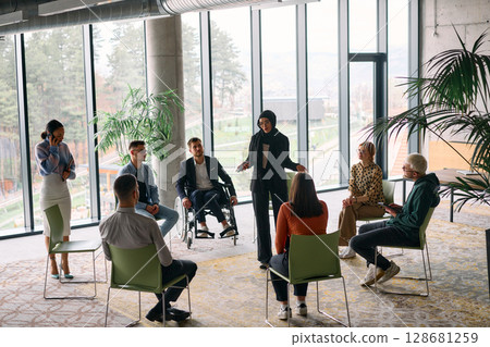 Corporate business team meeting with a manager or coach. Group of happy diverse, multiracial people sitting in a circle  128681259