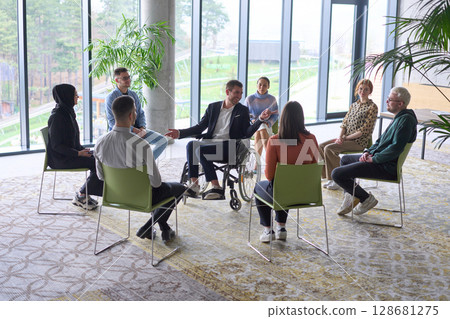 Corporate business team meeting with a manager or coach. Group of happy diverse, multiracial people sitting in a circle  128681275